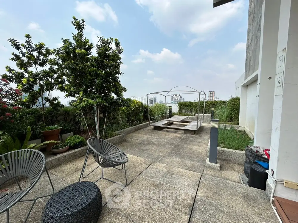 Spacious rooftop terrace with modern seating and lush greenery, perfect for relaxation and entertainment.
