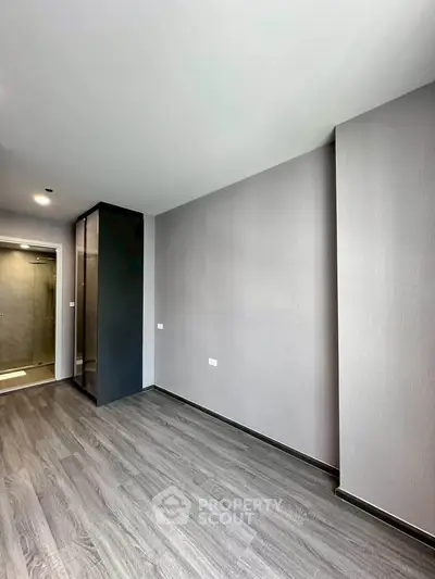 Spacious modern bedroom with sleek flooring and minimalist design, perfect for contemporary living.