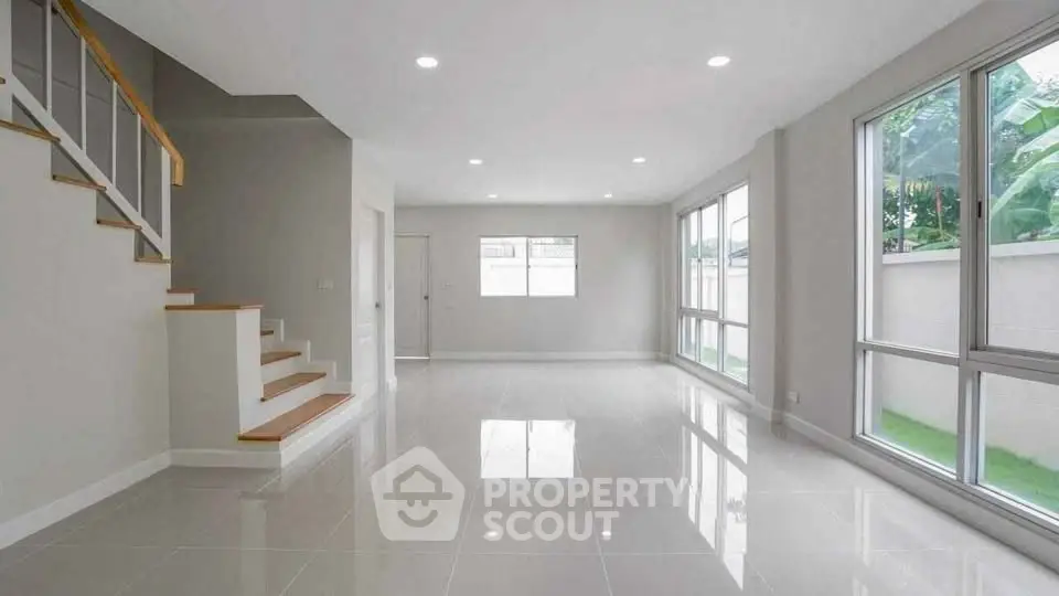 Spacious modern living room with large windows and glossy tiled floor