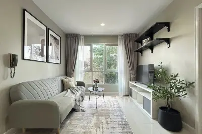 Modern living room with stylish decor, large window, and cozy seating area.