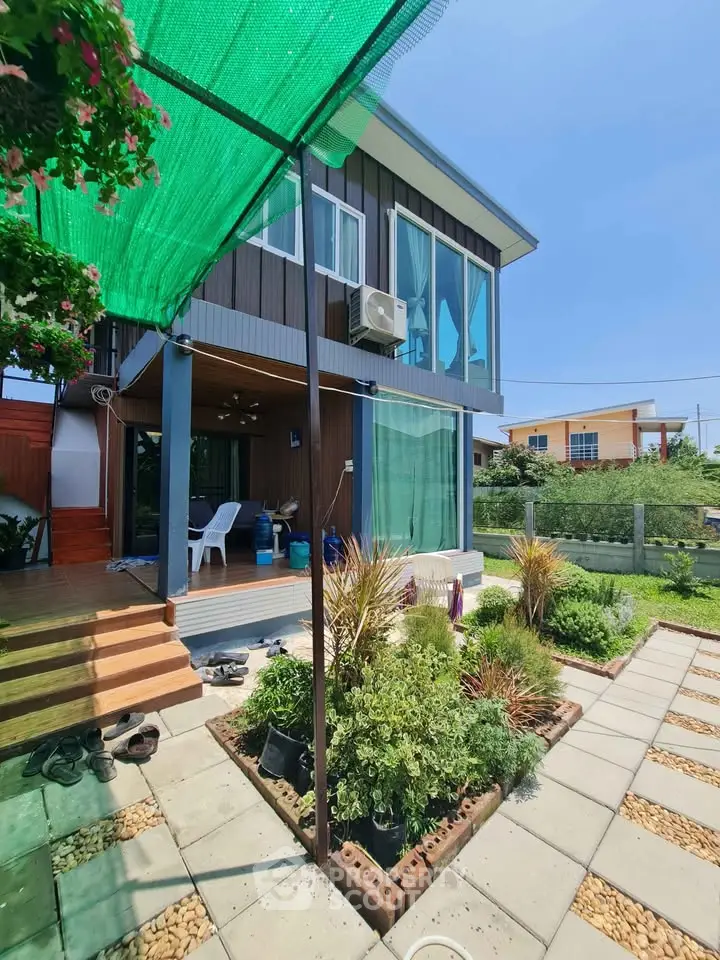 Charming modern house with lush garden and spacious patio, perfect for outdoor relaxation.