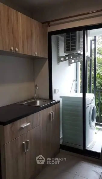 Modern kitchen with sleek cabinetry and washing machine on balcony