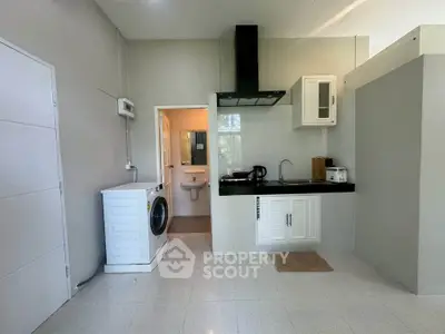 Modern kitchen with washing machine and sleek cabinetry in open layout