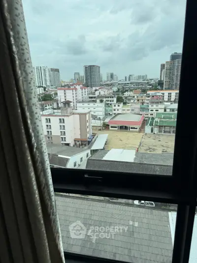 Stunning cityscape view from a high-rise apartment window, showcasing urban skyline and vibrant neighborhood.