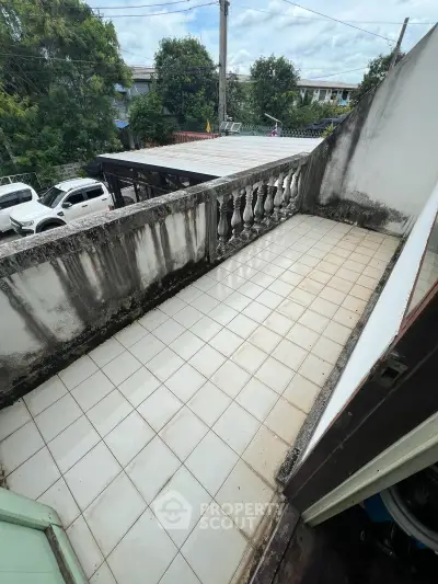 Spacious balcony with tiled flooring and classic balustrade, perfect for outdoor relaxation.