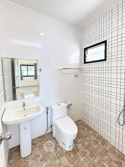 Modern bathroom with sleek white tiles and stylish fixtures in a contemporary home.