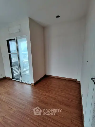 Bright empty room with wooden flooring and slanted ceiling window