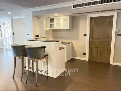 Modern kitchen with open layout and stylish bar stools in a spacious apartment.