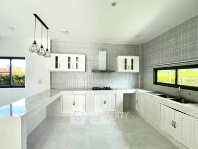 Spacious modern kitchen with sleek white cabinetry and gas stove