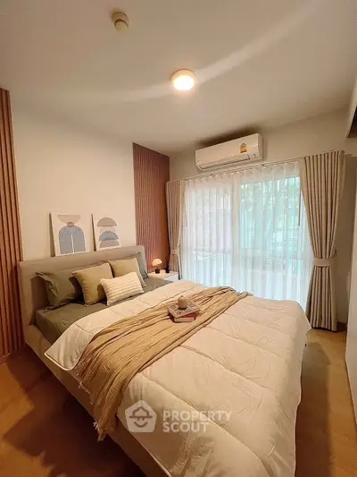 Cozy bedroom with stylish decor and large window for natural light