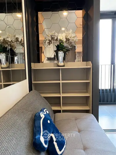 Stylish modern living room with hexagonal mirror decor and cozy seating area.