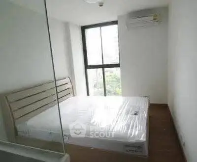 Bright bedroom with large window and air conditioning unit