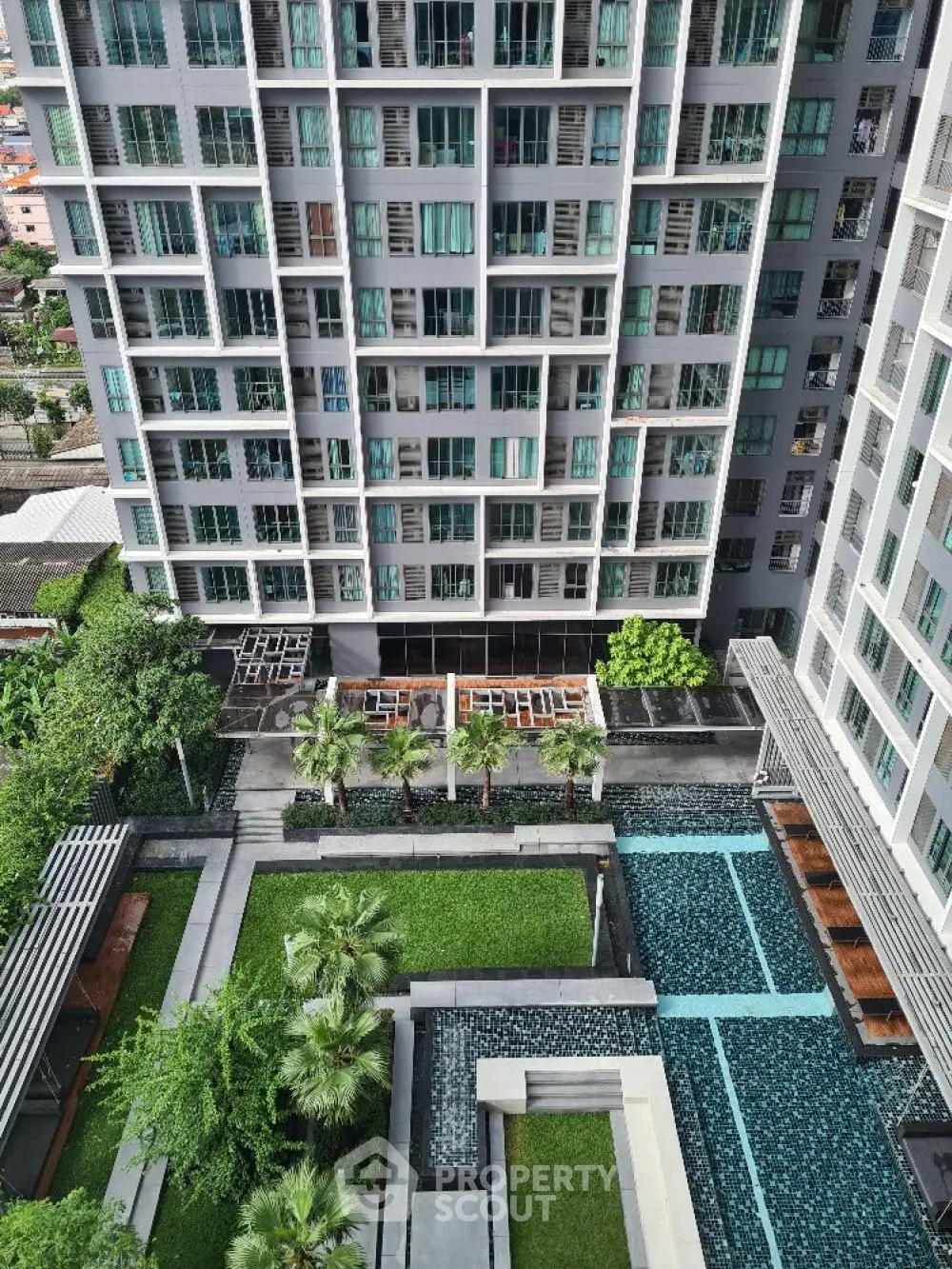 Modern high-rise building with lush garden and pool view