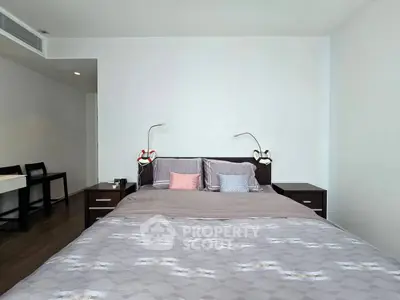 Spacious modern bedroom with stylish decor and ample natural light.