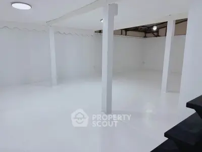 Spacious white basement with modern lighting and open layout, ideal for storage or creative use.