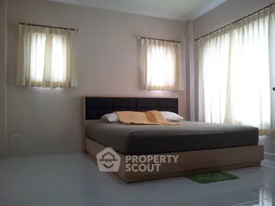 Spacious bedroom with natural light and modern decor, perfect for relaxation and comfort.