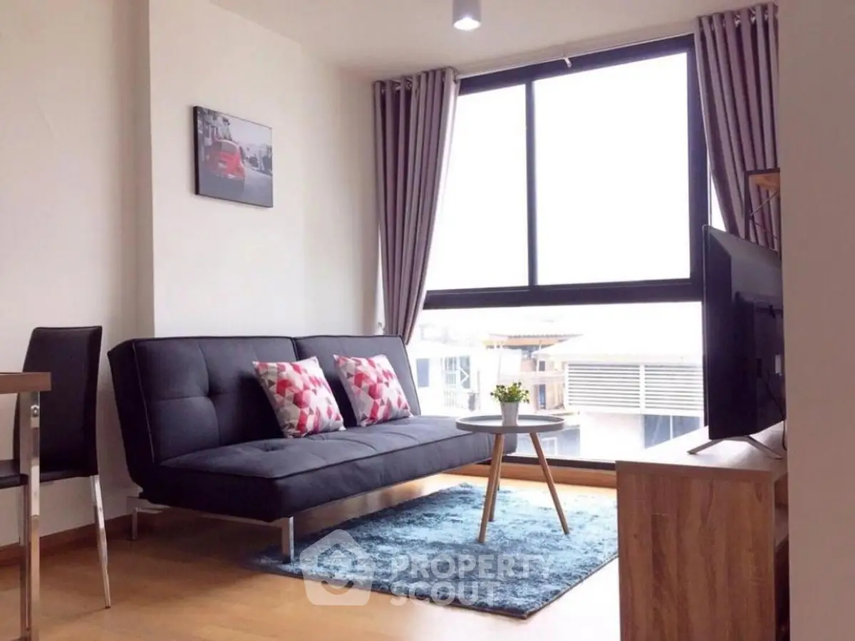 Modern living room with sleek sofa, large window, and stylish decor