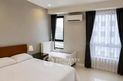 Modern bedroom with large window, air conditioning, and elegant furnishings in a high-rise apartment.