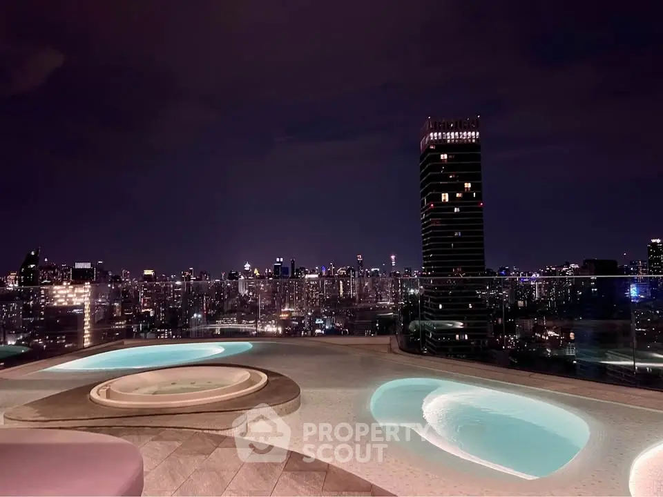 Stunning rooftop pool with breathtaking city skyline view at night, perfect for luxury living.