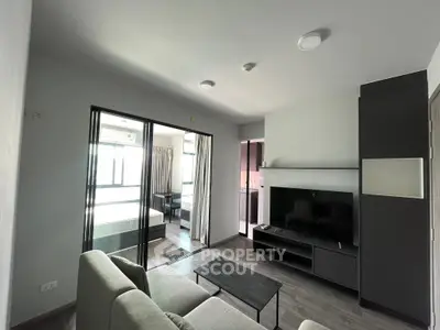 Modern living room with sleek furniture and open layout leading to a bedroom, ideal for urban living.