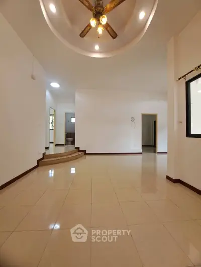 Spacious living room with elegant ceiling fan and tiled flooring