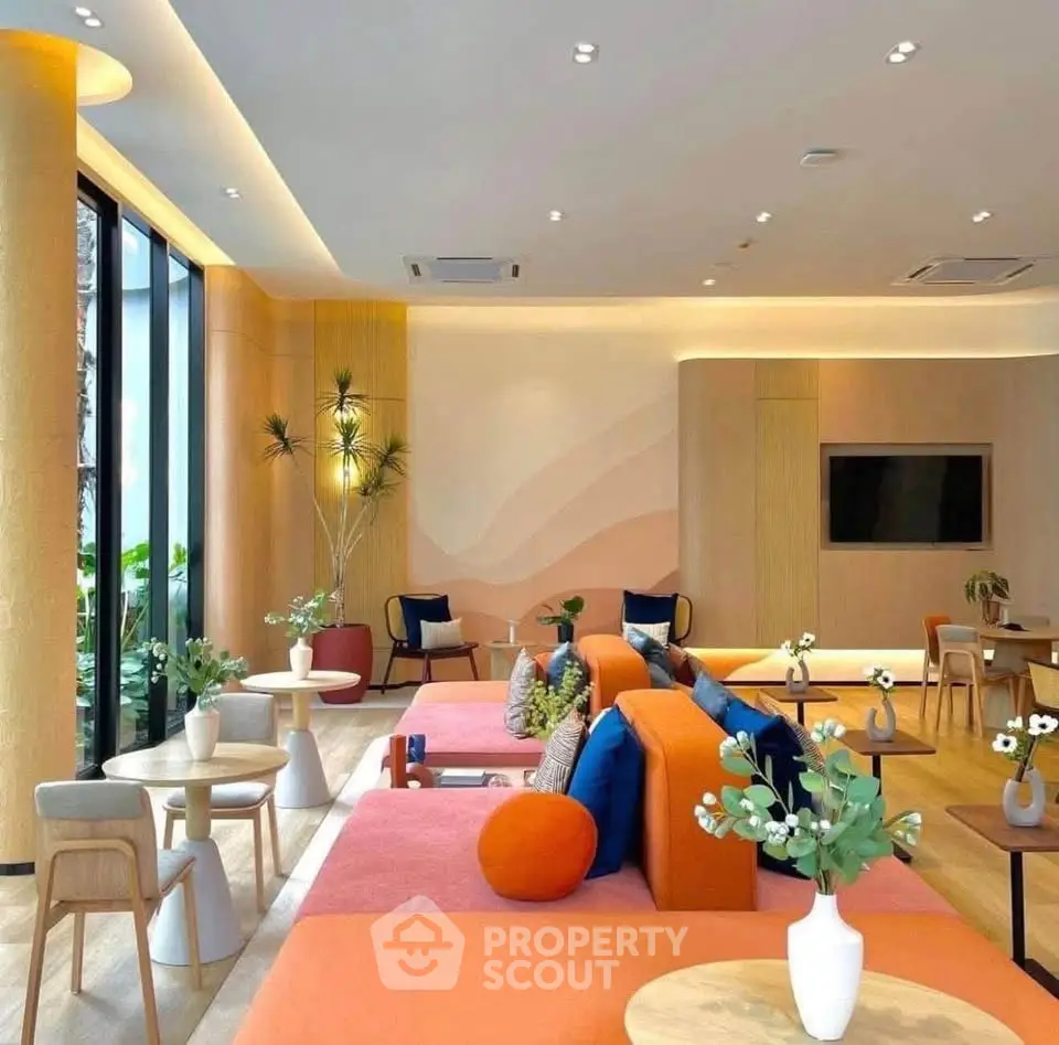 Modern living room with vibrant orange seating, stylish decor, and large windows offering natural light.
