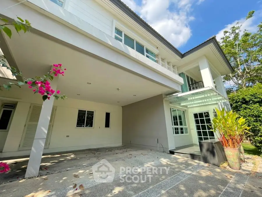 Spacious modern home exterior with lush garden and ample parking space.