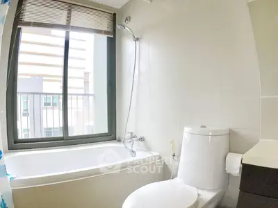 Modern bathroom with large window and bathtub in urban apartment