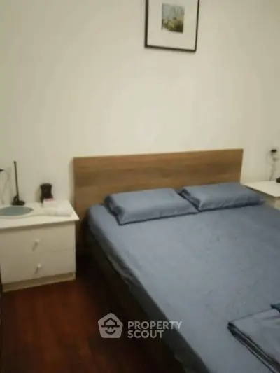 Cozy bedroom with wooden flooring and modern furnishings in a stylish apartment.