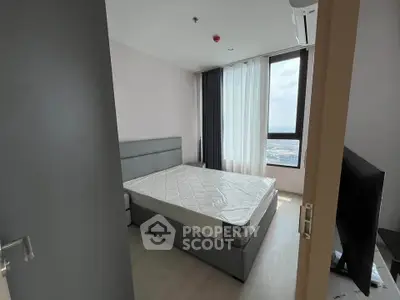 Modern bedroom with large windows and city view, featuring a stylish bed and sleek design.