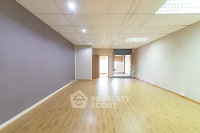 Spacious empty room with wooden flooring and neutral walls ideal for customization
