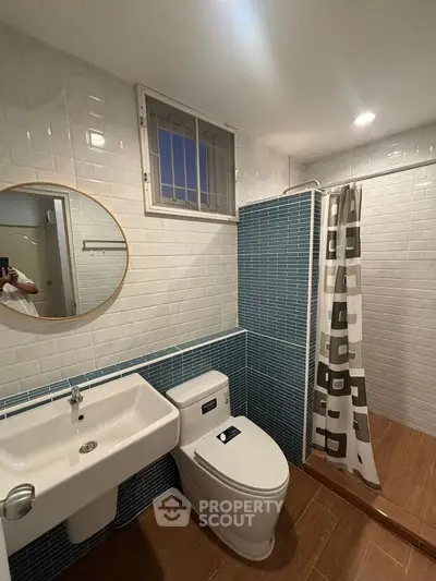 Modern bathroom with stylish blue tile accents and round mirror