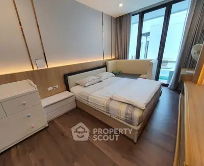 Spacious modern bedroom with large windows and elegant wooden flooring