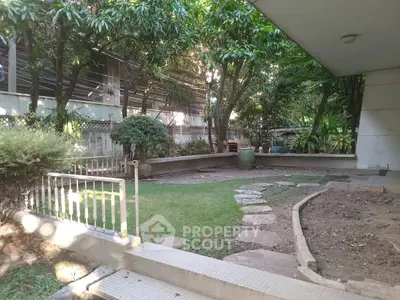 Charming garden area with lush greenery and stone pathway in a serene residential setting.