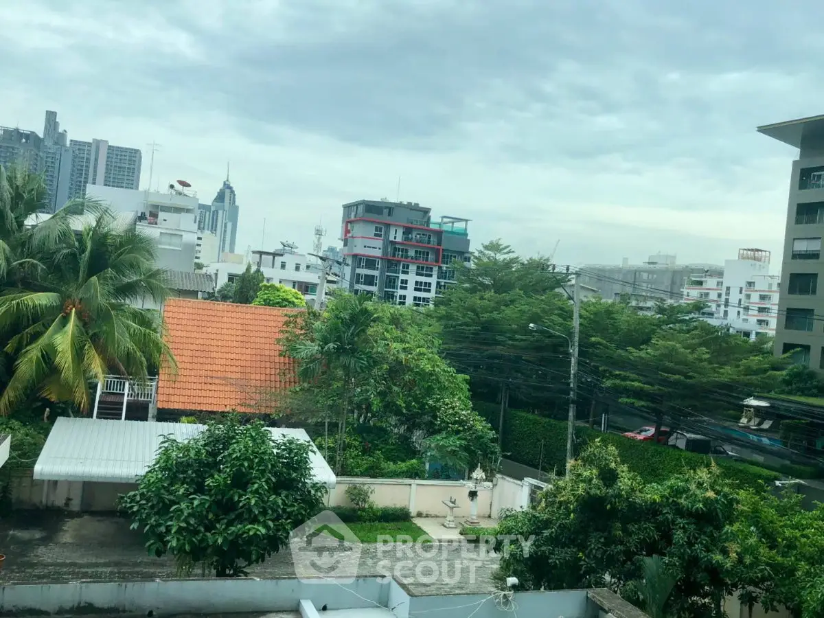 Stunning cityscape view from a high-rise apartment, showcasing lush greenery and modern architecture.