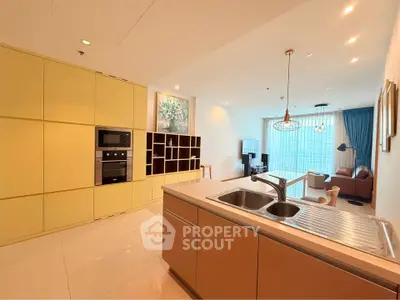 Modern open-plan kitchen and living room with stylish decor and ample natural light.