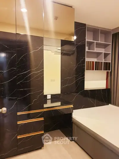 Luxurious bedroom with elegant black marble accents and built-in storage solutions.