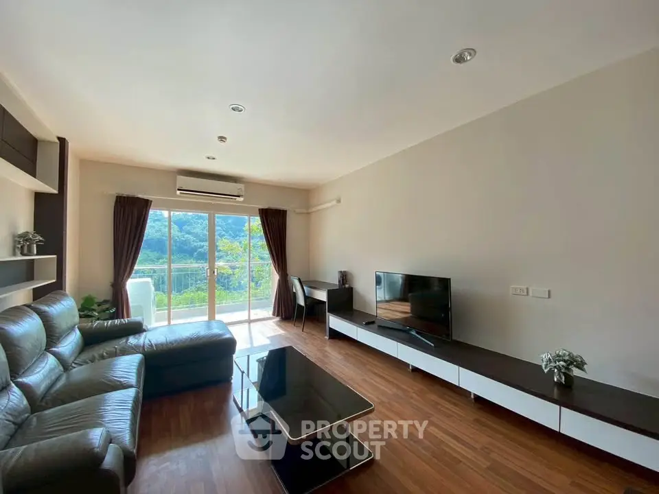 Spacious living room with modern furniture and scenic view from large window.