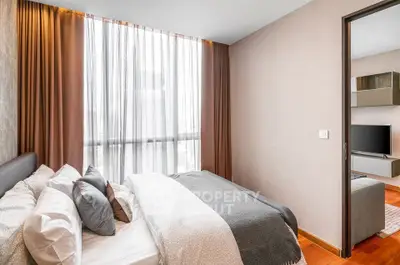 Modern bedroom with elegant decor and large window offering natural light