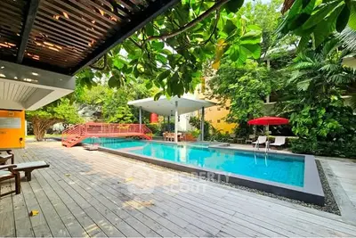 Luxurious outdoor pool area with lush greenery and modern design, perfect for relaxation and entertainment.