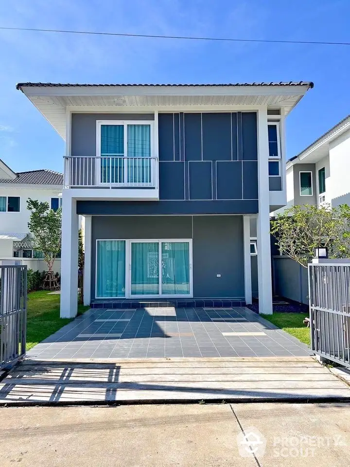 Modern two-story house with sleek design and spacious driveway in a serene neighborhood.