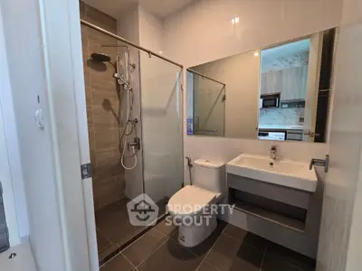 Modern bathroom with glass shower and sleek fixtures in contemporary apartment