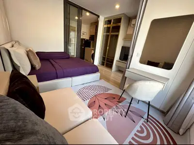 Modern studio apartment with stylish decor and open layout, featuring a cozy bed and chic workspace.