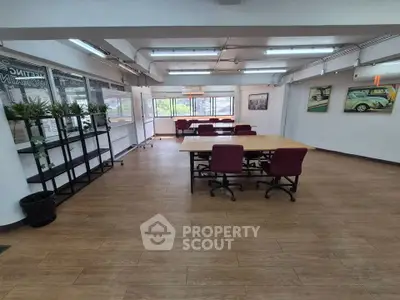 Spacious office space with modern furniture and large windows for natural light.