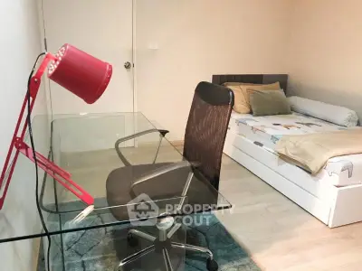Modern bedroom with glass desk and stylish chair, perfect for a cozy and functional living space.