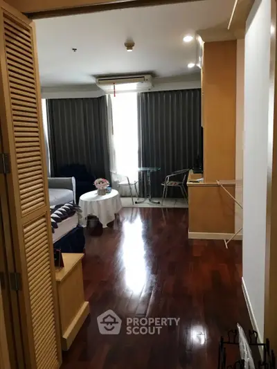 Spacious living room with wooden flooring and modern decor in a cozy apartment.