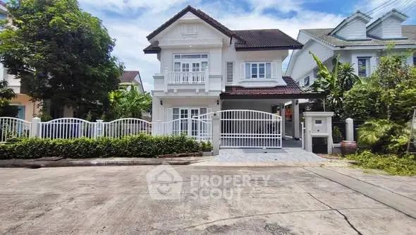 Charming two-story house with white facade and lush greenery in a serene neighborhood.