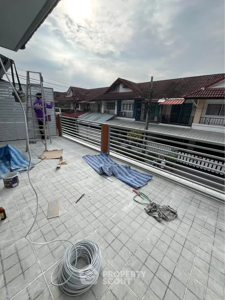 Spacious balcony with tiled flooring and street view, perfect for outdoor relaxation.