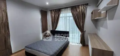 Spacious bedroom with modern decor and large window for natural light.