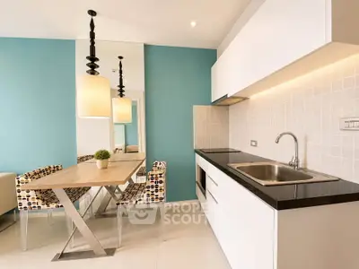 Modern kitchen with sleek white cabinets and stylish dining area in a contemporary apartment.